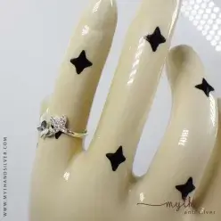 Silver butterfly ring shown on ceramic hand