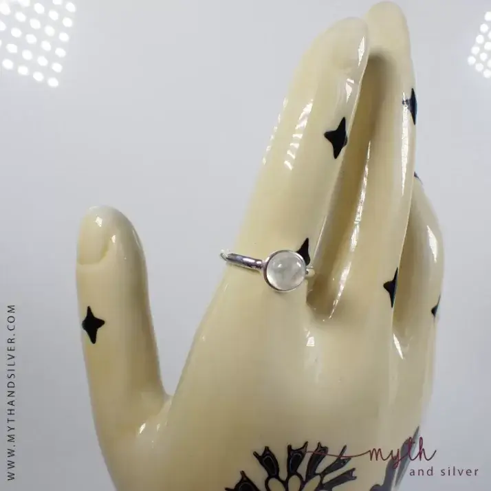 Circular moonstone ring on ceramic hand